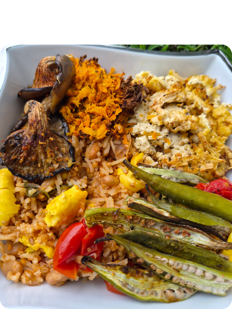 A vibrant plant-based meal bowl featuring roasted mushrooms, sweet potatoes, green beans, and quona from Vegans Can Cook Bakery